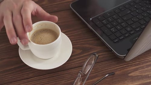 A Man Works At Home Using A Laptop Computer On A Wooden Table. Portrait Of A Business Man