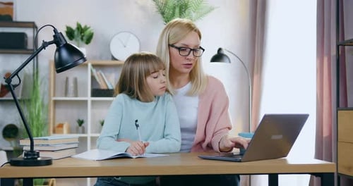 Mother Helping Child With Homework at Desk