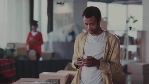 Man Checks Phone Man Reviews Order Details Attentively Individual Examining Phone in Workspace