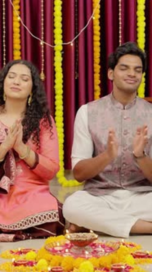 Couple in Traditional Clothing Sits in Prayerful Meditation