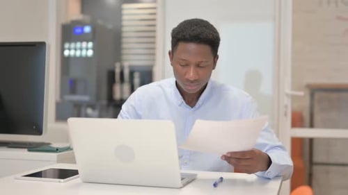 African Businessman Celebrating New Contract in Office