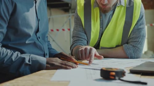 Architect and Building Contractor Discussing Floor Plan and Shaking Hands
