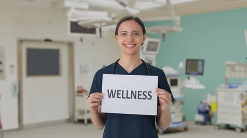 Happy Health Worker Holding Wellness Sign