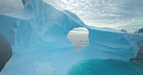 Giant Blue Melting Iceberg with Cave Drifts Ocean