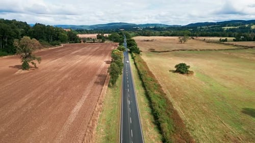 Forward flight tracking car on straight road through agricultural fields