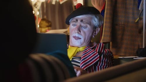 Clown in Makeup Looking at Laptop