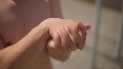 Man Rubbing Hands Together Outdoors Close-Up