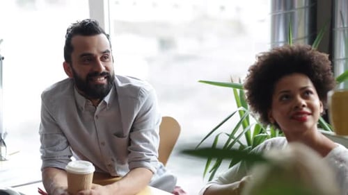 Happy multiethnic business team enjoying coffee break and chatting in office