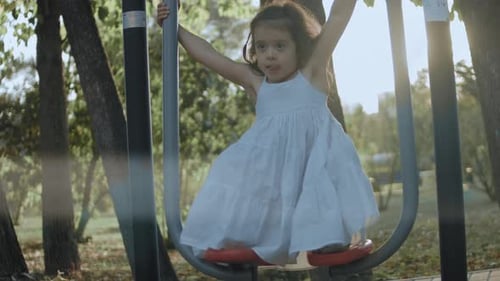 Girl Using Exercise Equipment in an Urban Park