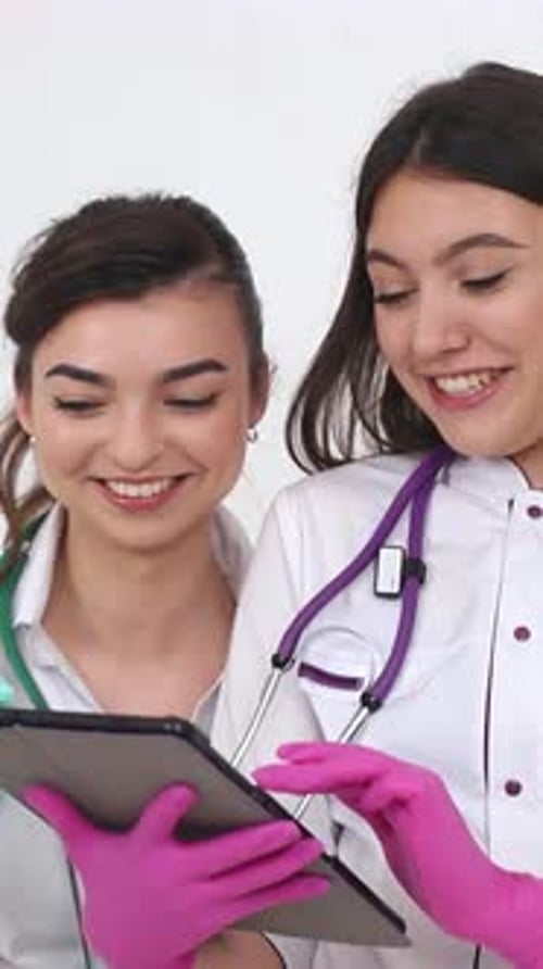 Hermosas jóvenes médicas usan la tableta iPod Hermosas enfermeras y tecnología