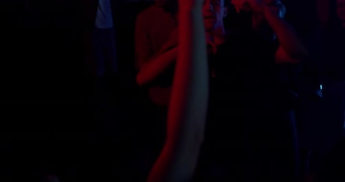 In der dunklen Nacht tanzen die Leute, hängen zusammen und genießen die Nachtparty bei Colourful Light und trinken Alkohol