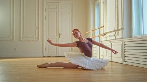 Young Ballerina Stretching in Dance Studio