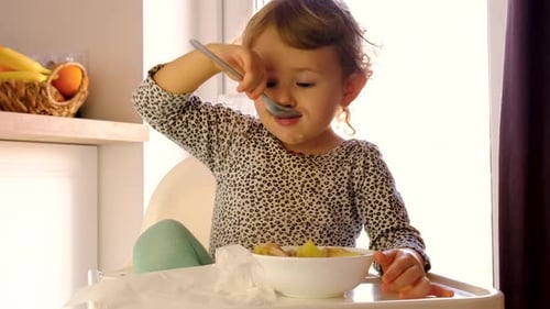 A criança come a sopa do prato