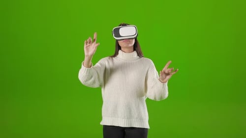 Woman Touching Air While Using VR Headset in Studio