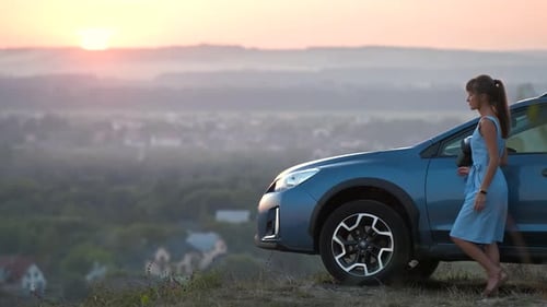 Woman Enjoying Sunrise Near Car in Rural Landscape