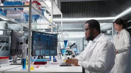 Scientist Typing at Computer in Modern Laboratory
