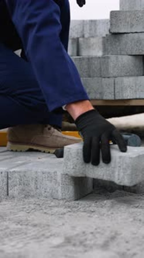 Construction Worker Installing Gray Paving Stones