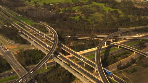 Interchange of highways, roads, ramps and overpasses. Busy traffic flow in the afternoon.