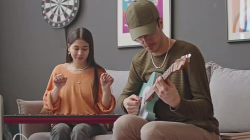 Young Woman and Man Jamming Together Indoors