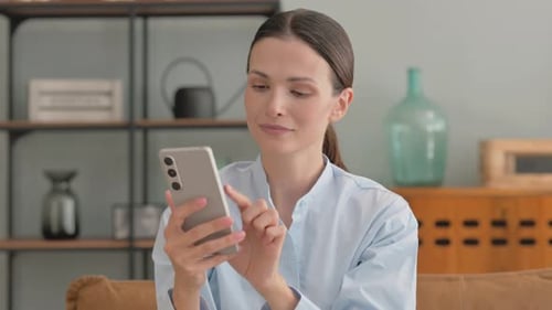 Woman using smartphone in modern home interior