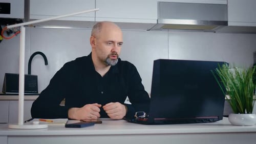 Man Engaging in Video Call at Kitchen Counter