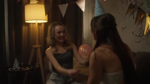 Young Women Celebrate Birthday Indoors with Party Hats