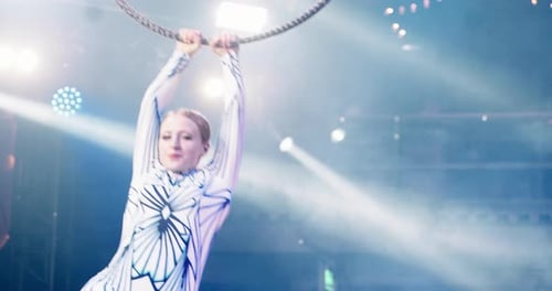 Singer and Aerialist Performing Under Bright Stage Lights