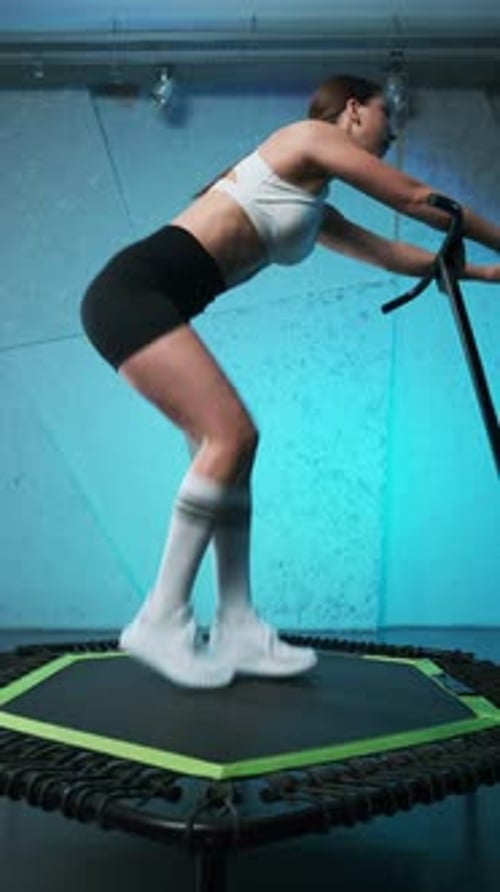 Young Woman Exercising on Trampoline with Handle
