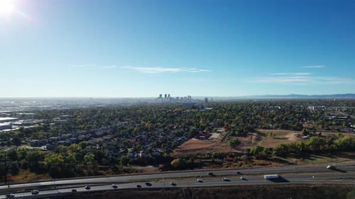Drone shot rising up over a highway outside of Denver, CO on a sunny fall day