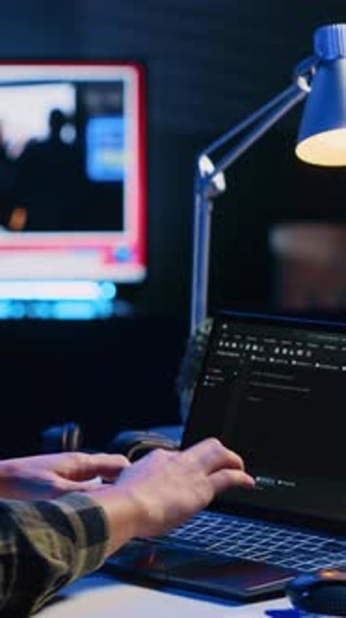 Vertikaler Videoprogrammierer schreibt Code auf den Laptop-Bildschirm, während er im Büro einer Wohnung mit Java ist