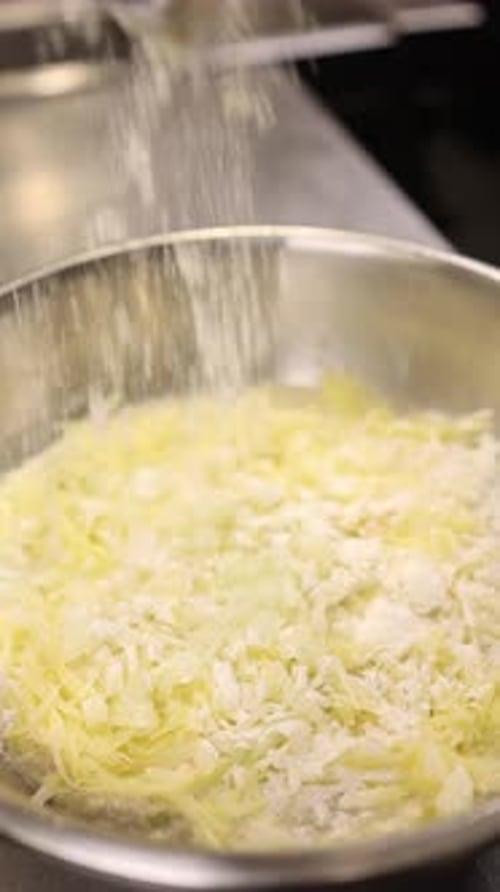 Le cuisinier prépare la pâte pour le plat national polonais placki ziemniaczane (galettes de pommes de terre).