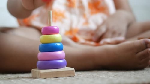 Kind spielt mit einem Babyspielzeug auf dem Bett Konzept zur Entwicklung von Kindern