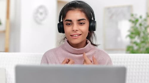 Smiling Woman Talking on Video Call with Headphones