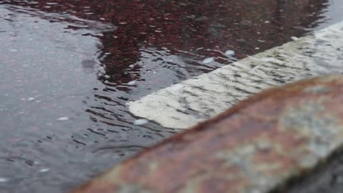 Rain water flowing in the gutter on the side of the road