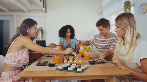 Group of friends eating sushi together at home.