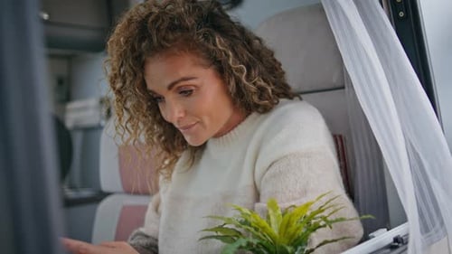 Woman Using Mobile Phone Inside of Camper Van