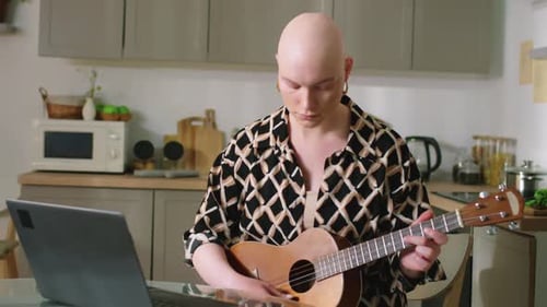 Young Woman Plays Ukulele in Home Kitchen
