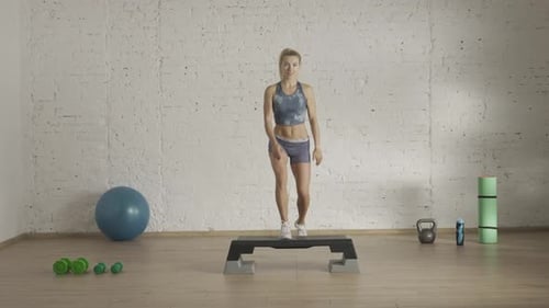 Woman Performing Step Aerobics in Indoor Workout Space