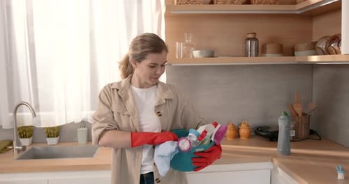 Woman Holds Cleaning Supplies Bucket in Kitchen