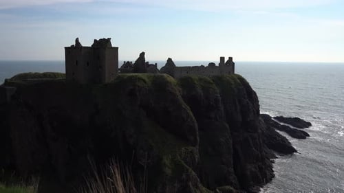 Majestic Dunnottar Castle in Scotland perched on a rocky promontory by the ocean, the castle is surr