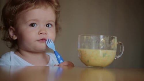 Adorable Toddler Eats Nutritious Soup Indoors