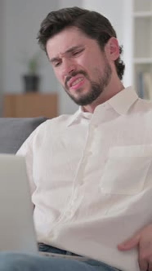 Man Using Laptop Massaging Lower Back in Pain