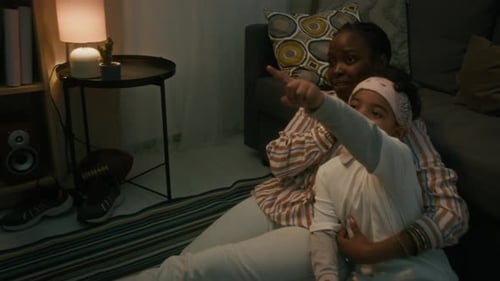 Loving Woman Embracing Child Sitting on Living Room Floor