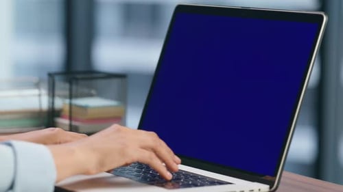 Unrecognizable ceo texting on chromakey laptop in modern office macro view