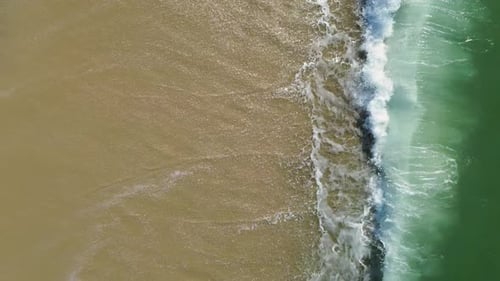 Vidéo aérienne par drone des vagues de l'océan Atlantique se jetant sur une plage de sable, belle vue de dessus de
