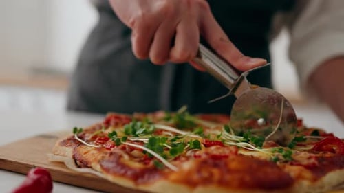 The Chef's Hand Close Up Cuts A Pizza Freshly Cooked In The Oven With A Circular Knife, The Cooked