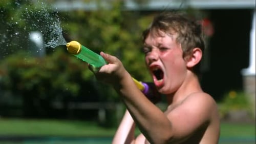 Energetic Boy Shoots Water From Toy in Summer