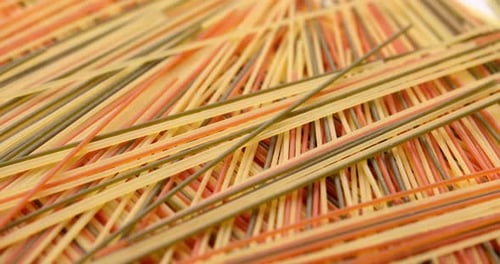 Nudel-Hintergrund, Makroansicht von trockenen, authentischen italienischen, bunten Spaghetti