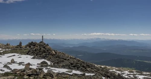 Time Lapse of Cloudscape Behind of the Mountains Top Snow Rocks Cliffs and Deep Blue Sky High