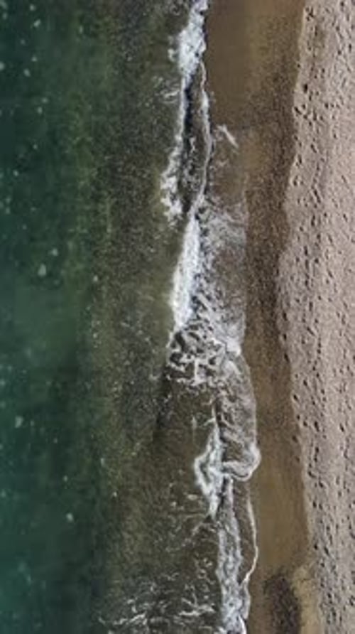Vertical Aerial View on Calm Azure Sea and Volcanic Rocky Shores Small Waves on Water Surface in